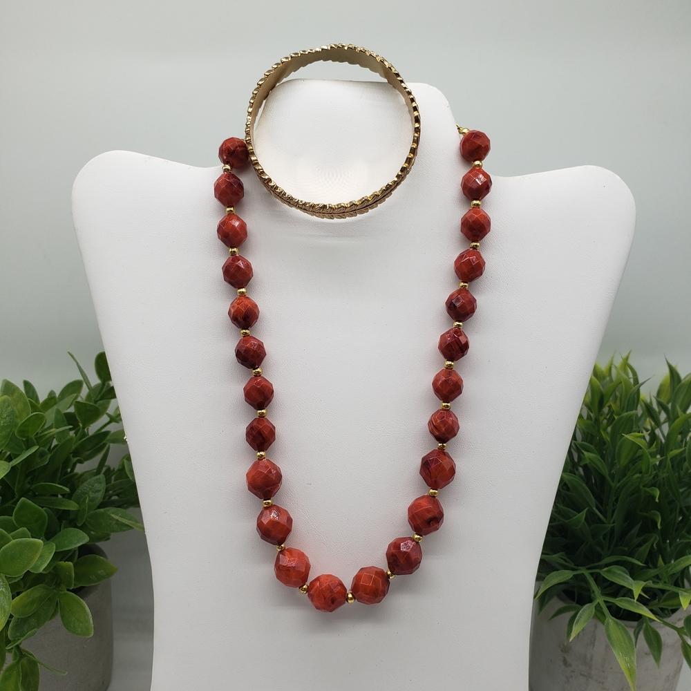 Red Beaded Gold Accent Necklace Paired with a Gold Tone Leaf Metal Bracelet